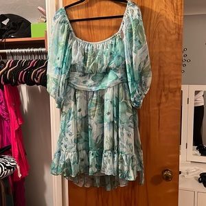 Green floral mini dress with ruffle bottom tie back and puff sleeves